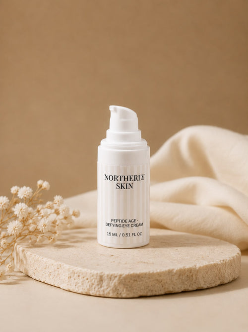 The 15 ml Peptide Age-Defying Eye Cream on a stone plinth with dried flowers